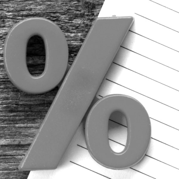 Black and white image of percentage sign with paper and wood in the background.