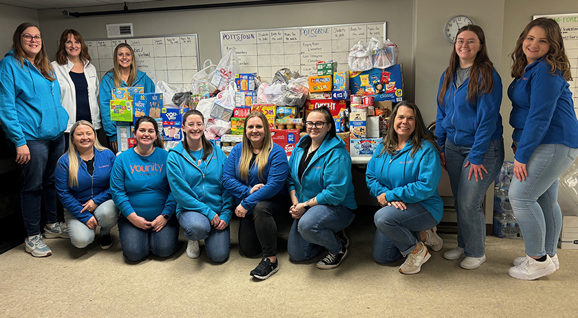 Diamond Credit Union volunteers are pictured at Operation 143 in Pottstown, Pa. with the food that was collected during their food drive in January. Eleven women that work for Diamond are pictured.