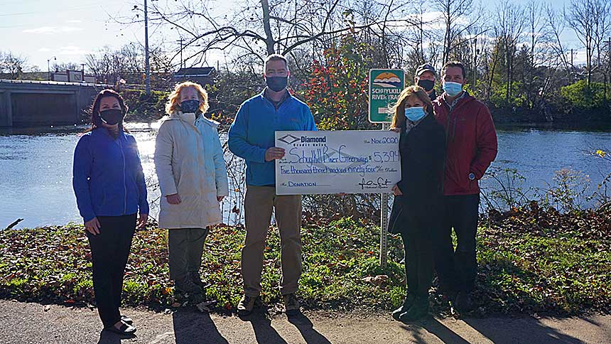 Photo: Representatives from Diamond Credit Union and Schuylkill River Greenways  National Historic Area smile behind their masks as Diamond presents a check to support SRG progams.